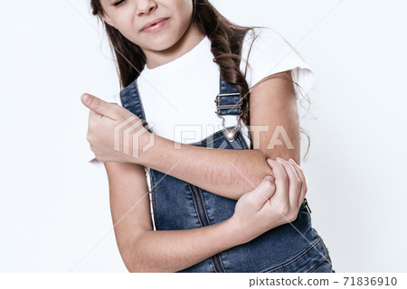 The girl has a pain in her arm. 71836910