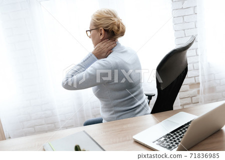 Girl sits at table in an armchair and feels pain. Girl sits at table in an armchair and feels pain. 71836985