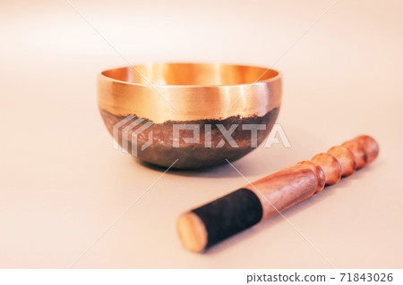 Bronze tibetan singing bowl with wooden stick on the white background 71843026