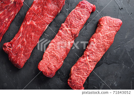 Raw, alternative beef steaks flap flank Steak, machete steak or skirt cut, Top blade or flat iron beef and tri tip, triangle roast with denver cut . Black stone background. Top view. 71843052