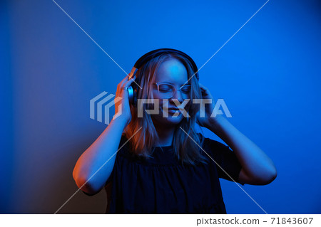 Young caucasian girl with glasses and headphones is enjoying the music Young caucasian girl with glasses and headphones is enjoying the music 71843607
