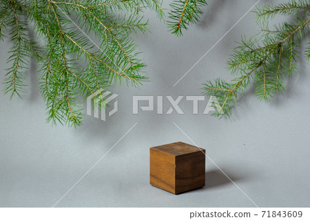 Wooden brown cube empty podium with fir branches on gray background Wooden brown cube empty podium with fir branches on gray background 71843609