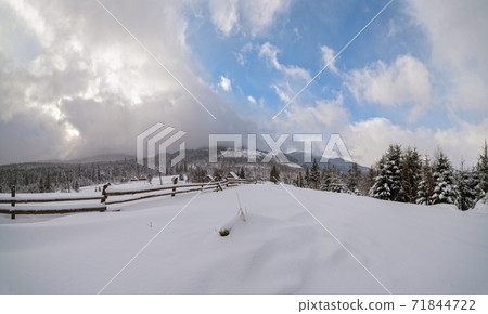 Countryside hills, groves and farmlands in winter remote alpine mountain village 71844722