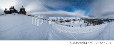 Countryside hills, groves, old wooden church on hill top and farmlands in winter remote alpine mountain village. Panorama, Voronenko, Ukraine. Countryside hills, groves, old wooden church on hill top and farmlands in winter remote alpine mountain village. Panorama, Voronenko, Ukraine. 71844725
