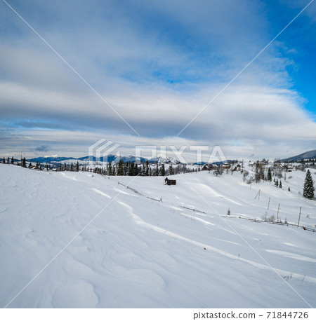 Countryside hills, groves and farmlands in winter remote alpine mountain village 71844726
