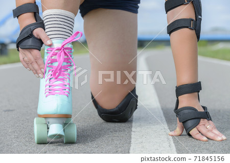 Woman rollerskater wearing knee protector pads 71845156