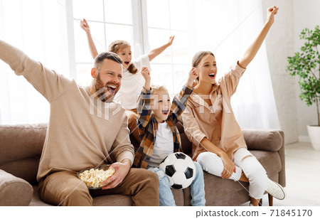 Excited family watching football at home. Excited family watching football at home. 71845170