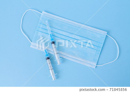 Coronavirus vaccination concept, syringes and mask on doctor table top view Coronavirus vaccination concept, syringes and mask on doctor table top view 71845856