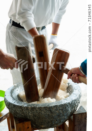 A man kneading glutinous rice with a pestle A man kneading glutinous rice with a pestle 71846345