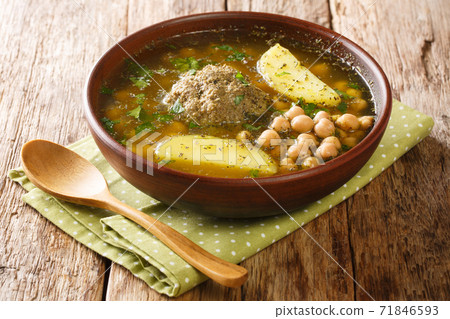 Authentic kufta bozbash meat soup with lamb meatballs, chickpeas, vegetables and herbs close-up in a plate. horizontal Authentic kufta bozbash meat soup with lamb meatballs, chickpeas, vegetables and herbs close-up in a plate. horizontal 71846593