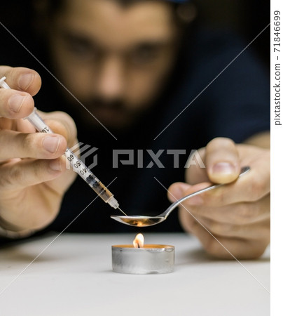 A man preparing a dose of cocaine. A man preparing a dose of cocaine. 71846699