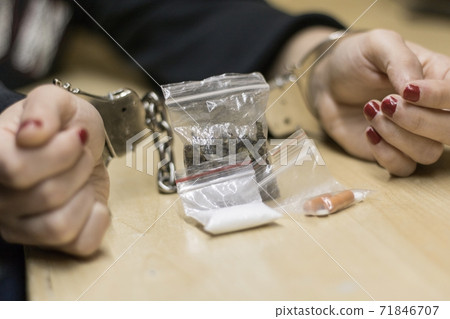 Woman arrested and handcuffed for drug dealing.  71846707