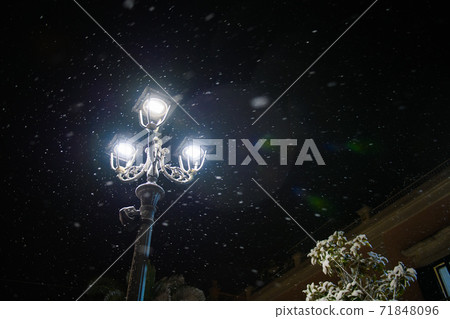 Old street lamp in snowfall during the winter night 71848096