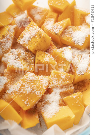 Slices of fresh pumpkin with seasonings on paper in a glass bowl before baking. Cooking Vegetarian Vegetarian Dishes Slices of fresh pumpkin with seasonings on paper in a glass bowl before baking. Cooking Vegetarian Vegetarian Dishes 71848412