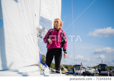 A young girl is photographed on board of a white sports yacht she bought to participate in a sailing regatta. 71848848