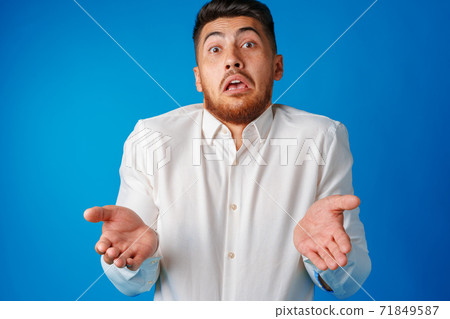 Portrait of young nerd man shrugging shoulders, I don't know gesture 71849587