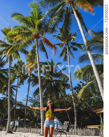woman streching with palm trees on white sand beach at Paliton Beach in Siquijor Island, Philippines. Tropical summer vacation concept woman streching with palm trees on white sand beach at Paliton Beach in Siquijor Island, Philippines. Tropical summer vacation concept 71850023