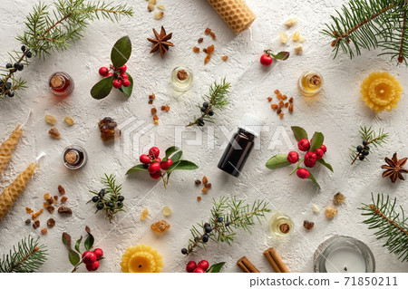 Christmas selection of essential oils with frankincense, myrrh, wintergreen, juniper, cinnamon, star anise and candles 71850211