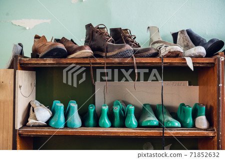 In the workshop in a wooden rack are colored blanks for different shoes In the workshop in a wooden rack are colored blanks for different shoes 71852632
