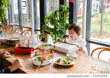 A boy receives a beautiful present at dinner 71852656