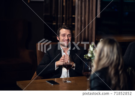 a couple in love celebrates their anniversary in a restaurant at a table with a bouquet of flowers a couple in love celebrates their anniversary in a restaurant at a table with a bouquet of flowers 71852852