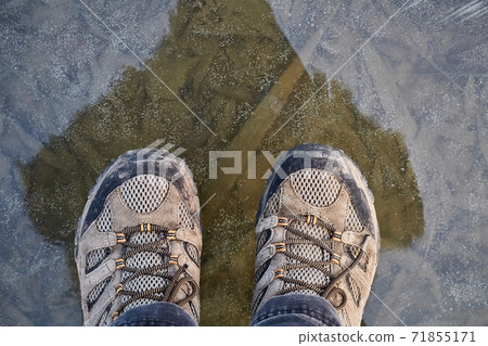 Standing on ice of frozen lake 71855171