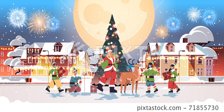 santa woman standing with deer and mix race elves in masks new year merry christmas holiday celebration 71855730