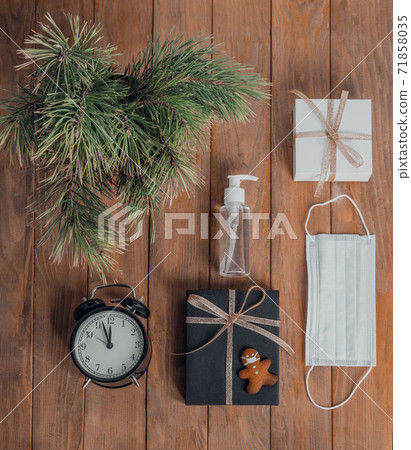 Christmas business composition. Gifts, black and golden decorations on wooden background. Cookies in the form of a man in a mask. Holiday concept in the context of the coronavirus pandemic Christmas business composition. Gifts, black and golden decorations on wooden background. Cookies in the form of a man in a mask. Holiday concept in the context of the coronavirus pandemic 71858035