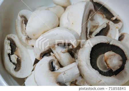 Closeup of a pile of raw white button mushrooms. Closeup of a pile of raw white button mushrooms. 71858841