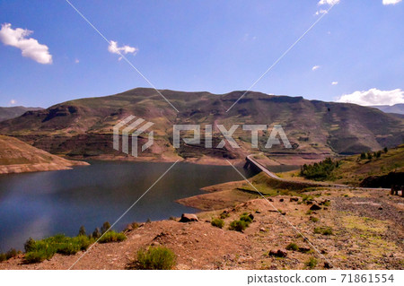 在非洲王國租車的場景。壯麗的山脈和盛開的波斯菊，特色鄉村房屋等 71861554