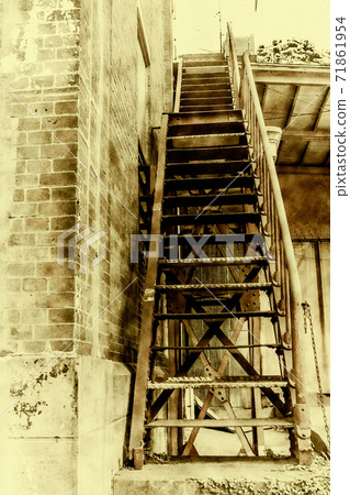 Rusted stairs in a brick warehouse 71861954