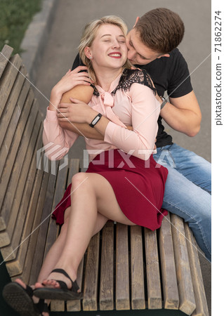 Young couple kissing at the bench on the street 71862274