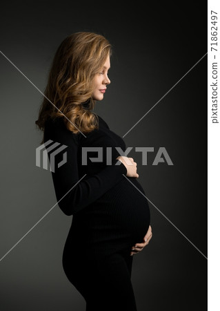 Pregnant woman in black dress in studio Pregnant woman in black dress in studio 71862497