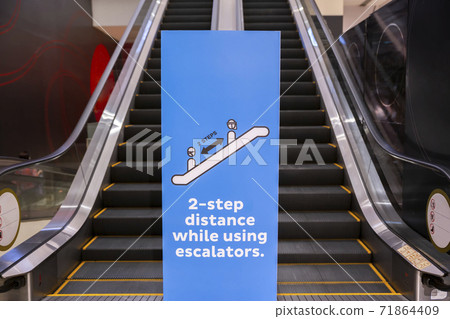Social distancing sign for warning to keep social distance between each other to protect Coronavirus (CoVID-19) when on escalators.. Social distancing sign for warning to keep social distance between each other to protect Coronavirus (CoVID-19) when on escalators.. 71864409