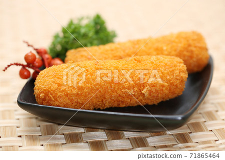 Korokke or Croquette the traditional japanese food two slice a deep-fried dish mashed potatoes or imo cheese. serving on the plate and two slice close up with bamboo woven background Korokke or Croquette the traditional japanese food two slice a deep-fried dish mashed potatoes or imo cheese. serving on the plate and two slice close up with bamboo woven background 71865464