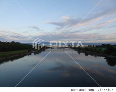 A view of the river surface reflecting the early morning sky, rivers, mountains, highway bridges, radio towers, and towns A view of the river surface reflecting the early morning sky, rivers, mountains, highway bridges, radio towers, and towns 71866107