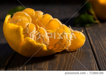 Peeled tangerine on a dark background with space for text. Wallpaper, poster. Peeled tangerine on a dark background with space for text. Wallpaper, poster. 71866190