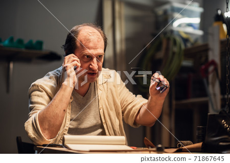 a dissatisfied customer calls the store's support service, talks on the phone, and is angry. a dissatisfied customer calls the store's support service, talks on the phone, and is angry. 71867645