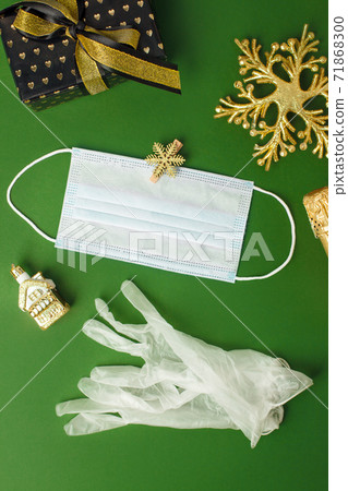 Gloves, bottle champagne, facemask, gift present box, gold decor on natural green background. Party concept, winter holiday in pandemy, coronavirus, self-isolation, banner on natural green Gloves, bottle champagne, facemask, gift present box, gold decor on natural green background. Party concept, winter holiday in pandemy, coronavirus, self-isolation, banner on natural green 71868300