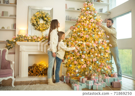 Young cute family decorating christmas tree together Young cute family decorating christmas tree together 71869250