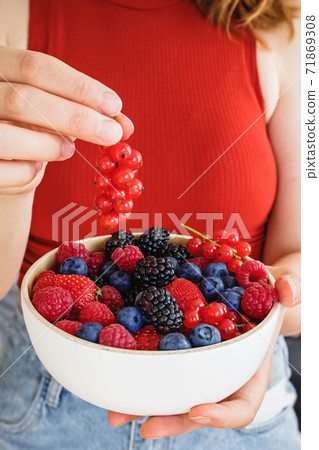 Female hands holding a bowl of delicious summer berries, Female hands holding a bowl of delicious summer berries, 71869308