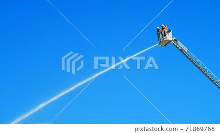 Fire brigade extinguishing fires with ladder trucks 71869768