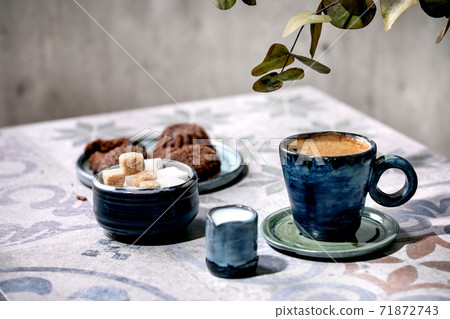 Cup of coffee, milk, sugar and cookies on ceramic table. Sun light, shadows 71872743