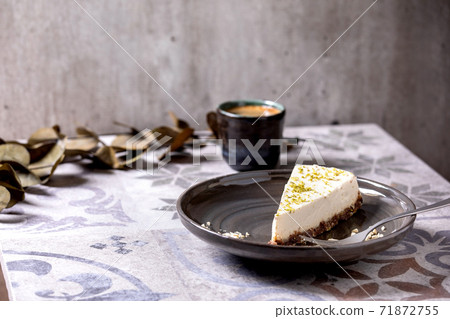 Raw vegan cheesecake with lime zest and cashew nuts on plate 71872755