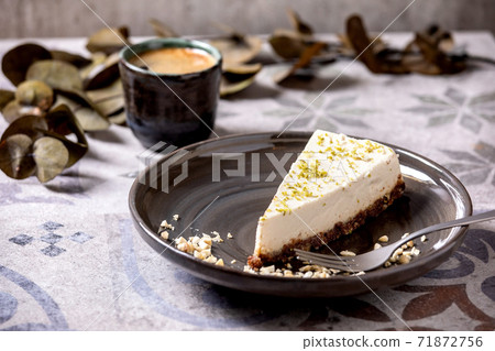 Raw vegan cheesecake with lime zest and cashew nuts on plate 71872756