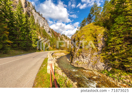 Road through a rocky gorge in a mountain valley at autumn. Road through a rocky gorge in a mountain valley at autumn. 71873025