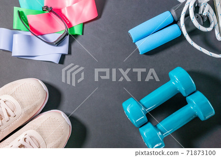fitness sneakers, fitness bracelet, jump rope, dumbbells, elastic expander at the ankles. Lifestyle and health. flat lay. place to copy text fitness sneakers, fitness bracelet, jump rope, dumbbells, elastic expander at the ankles. Lifestyle and health. flat lay. place to copy text 71873100