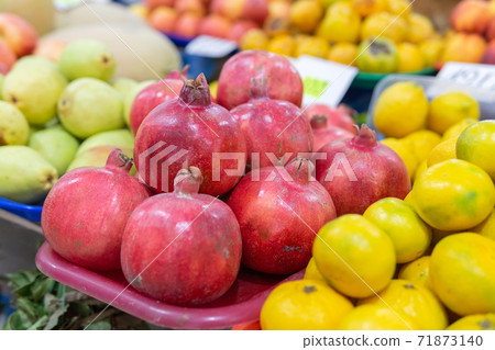 Pomegranate fruits close-up kept for sale in the street of market. selective focus Pomegranate fruits close-up kept for sale in the street of market. selective focus 71873140