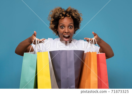 African woman with colorful shopping bags being excited with her purchases. African woman with colorful shopping bags being excited with her purchases. 71873325