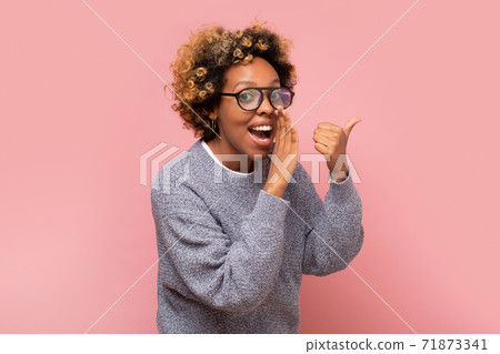 Young african american woman with hand on mouth telling secret or rumor, whispering. 71873341